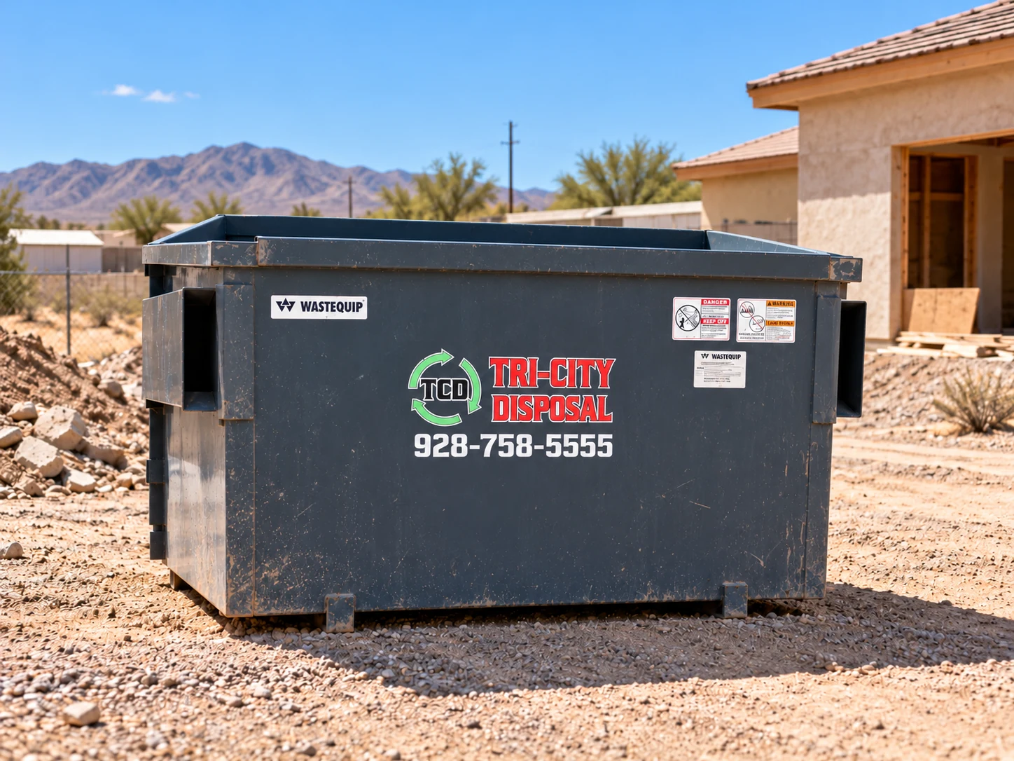 Tri-City Disposal branded front-load dumpster at a desert construction site — illustrative composite